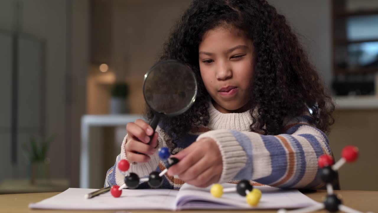 一个小女孩独自坐在家里用放大镜做科学作业的4k视频片段视频下载