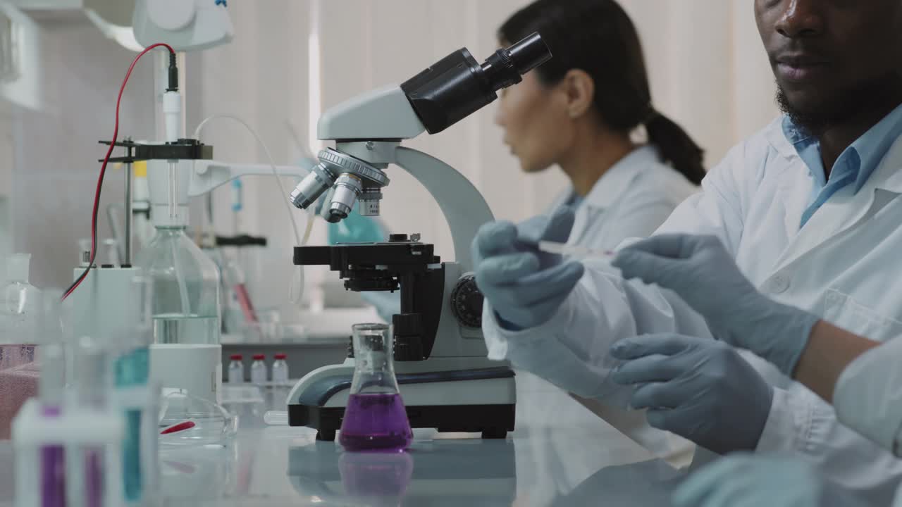 穿着实验室外套和手套做研究的科学家视频素材