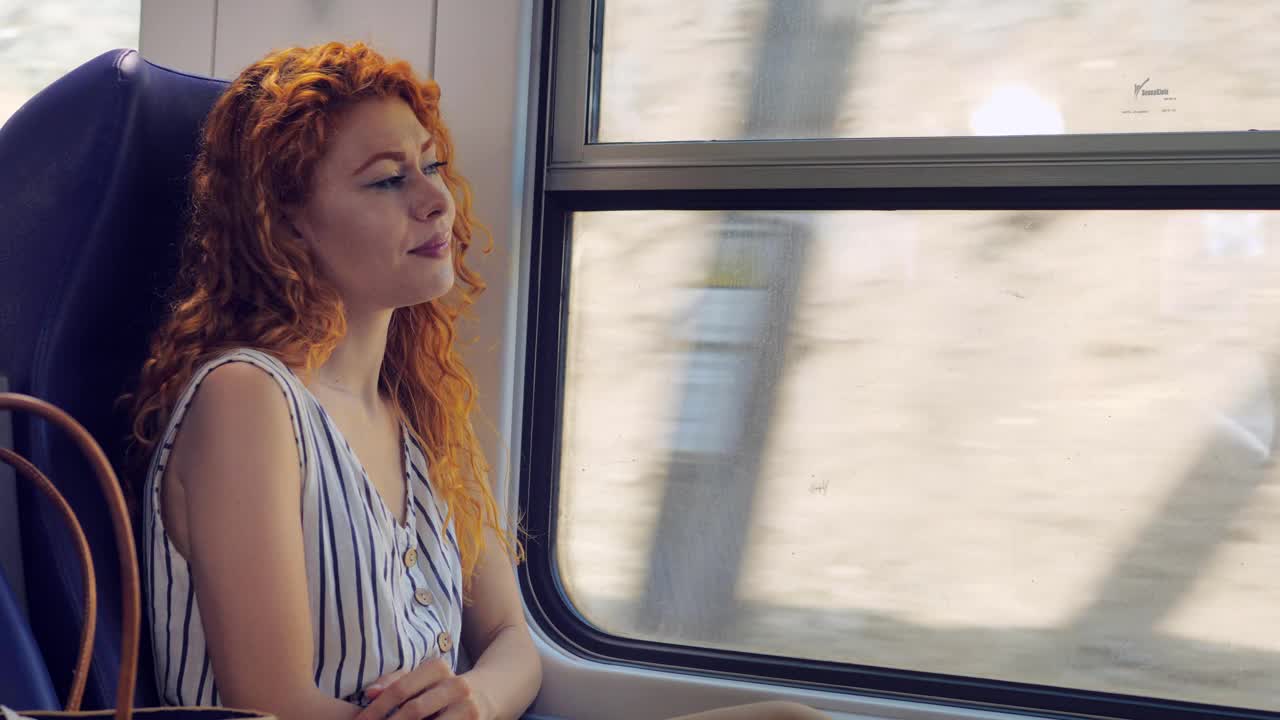 坐火车旅行的自信女人会开心地想着她的假期视频素材
