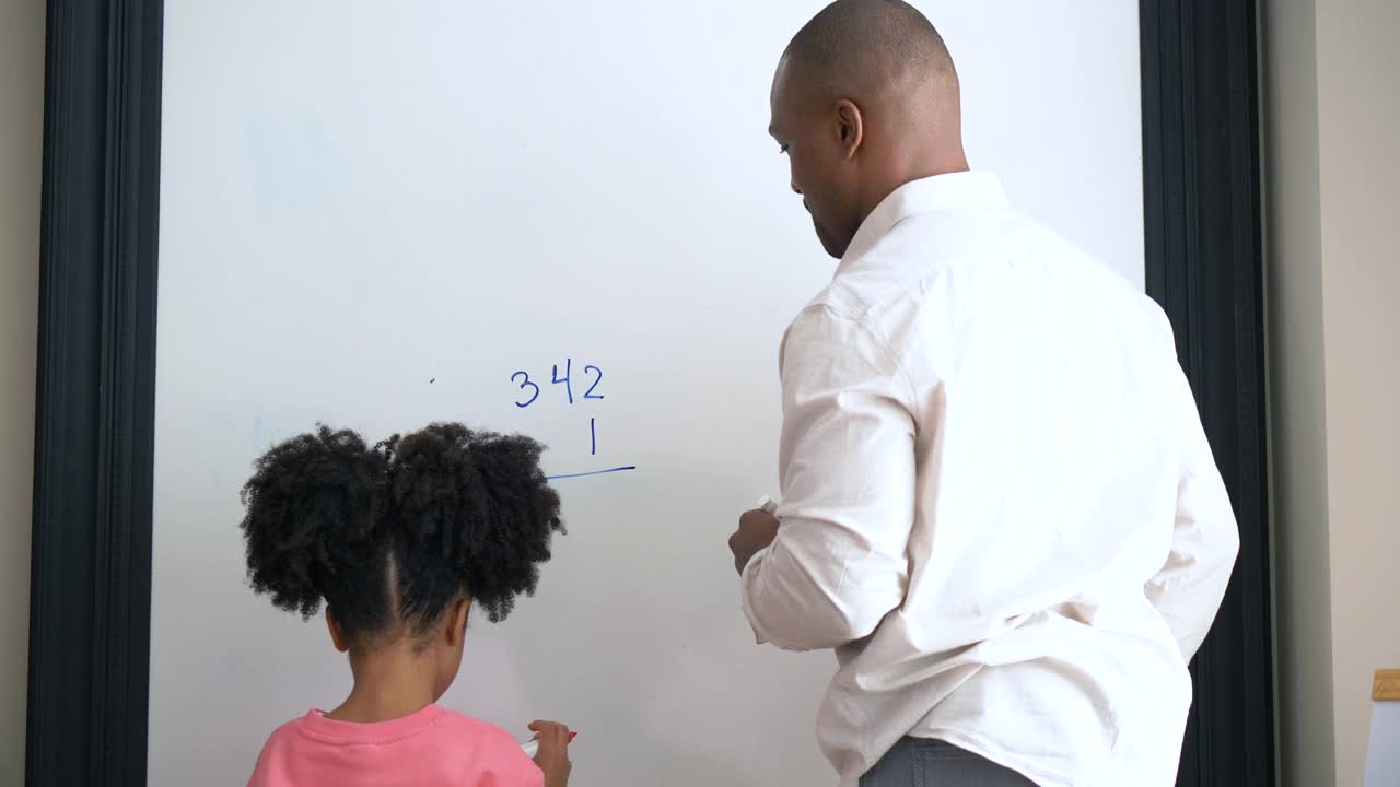 父亲在家教育女儿，在白板上做数学视频素材