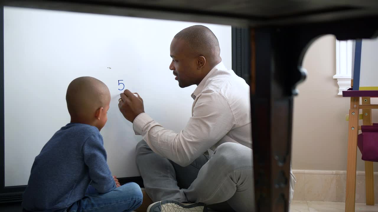 父亲在家教育儿子，在白板上做数学视频素材
