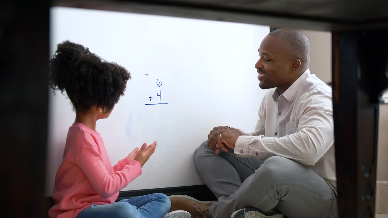 父亲在家教育女儿，在白板上做数学视频素材