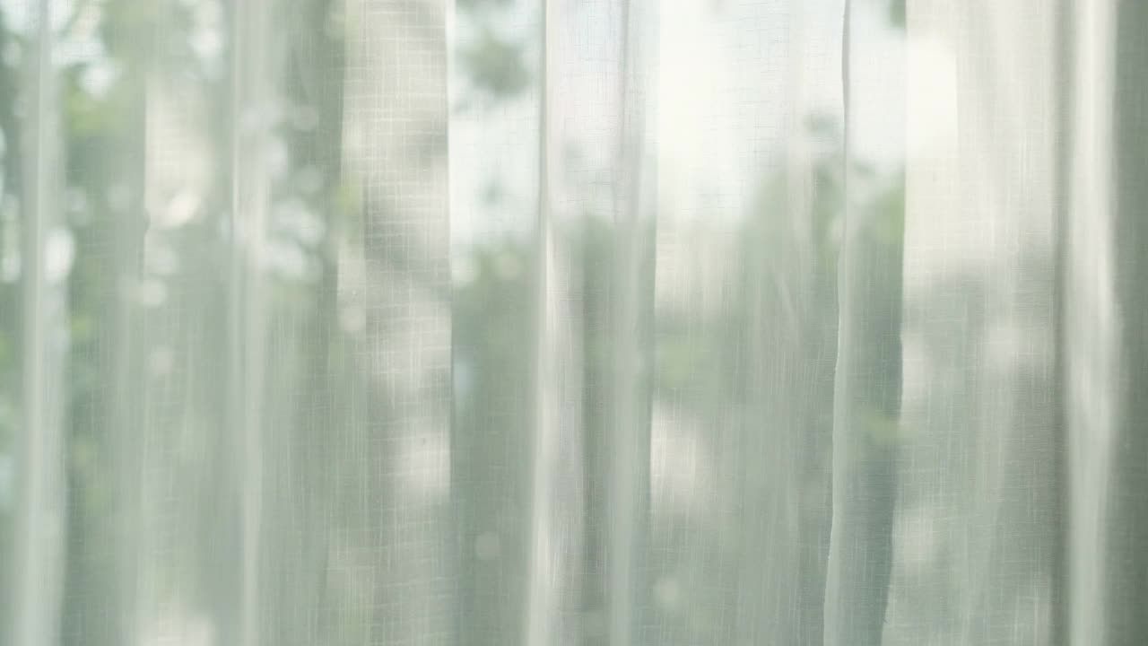 阳光透过窗帘从窗口卧室的视野与绿色花园后面视频下载