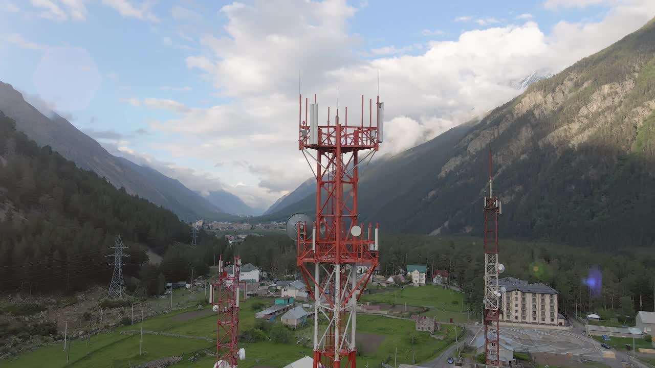 移动通信塔位于大山之间的小镇上视频素材
