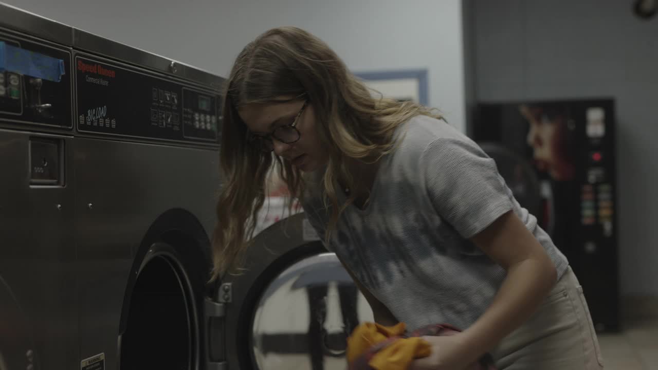 美国犹他州普罗沃，一名女孩从洗衣机里取出衣服，惊讶地发现内衣混在一起了视频素材