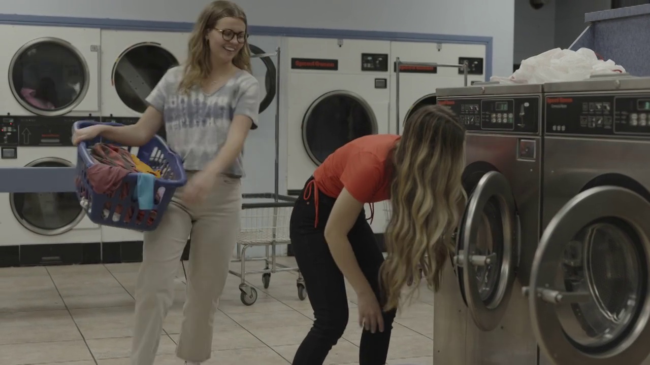 女孩提着洗衣篮嬉戏地踢着惊讶的朋友/普罗沃，美国犹他州视频素材