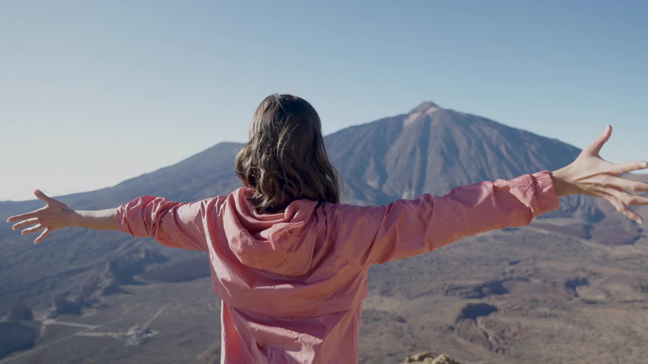 幸福和自由。女人在岩石嶙峋、干燥的风景中张开双臂视频素材