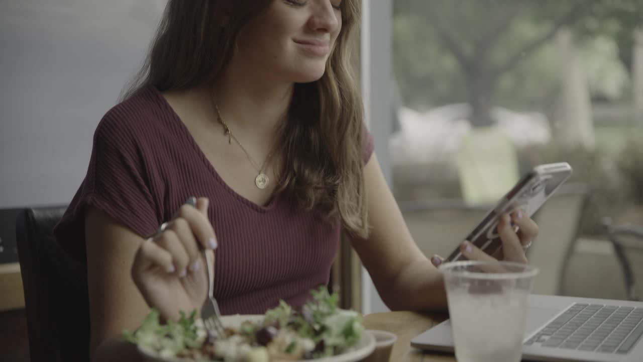 近距离的女人在餐馆吃饭和使用手机约会应用程序/普罗沃，犹他州，美国视频下载