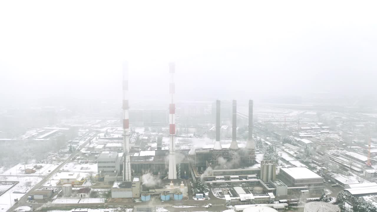 在浓雾中，4K无人机从火力发电厂的烟囱间飞过视频素材