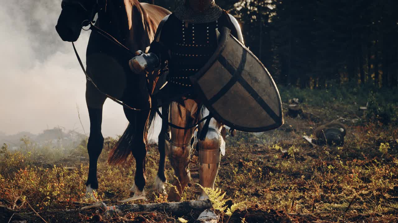 中世纪骑士战士带领他的马进入战斗。英雄的肖像在镀甲，盾，头盔，剑和纯种马。电影之光，战争，烟雾，入侵，征服视频素材