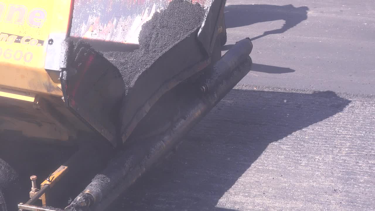履带式摊铺机在路面上铺设新的沥青路面视频下载