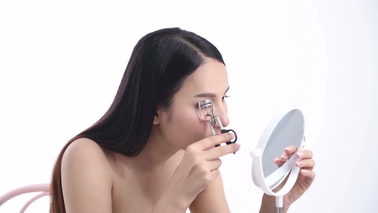 一位亚洲女性博主正在展示如何化妆和使用化妆品。在摄像机前录制视频直播流媒体在工作室视频下载