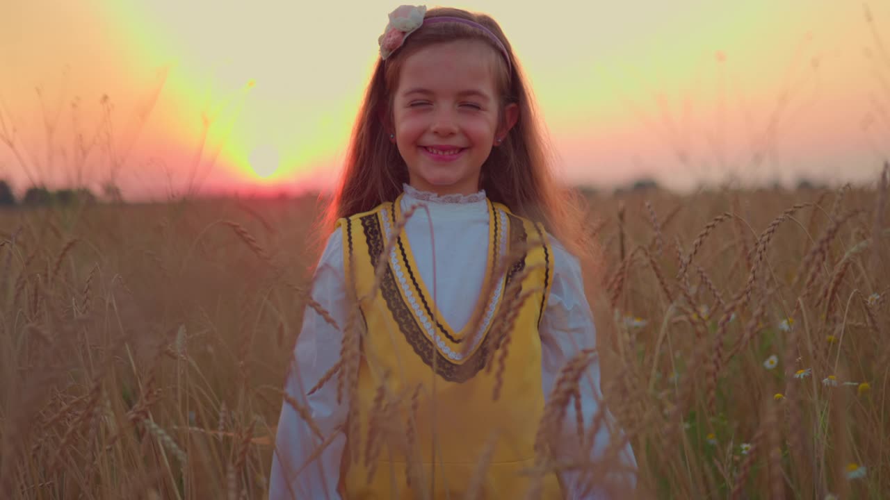 自由的小女孩穿着民间传说中的保加利亚服装，享受麦田里的收获时间在日落视频下载