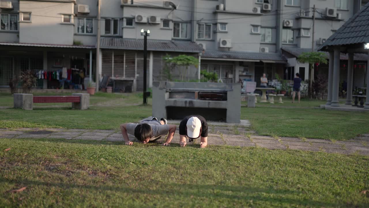 亚洲华人母亲和儿子一起在后院户外锻炼。视频下载