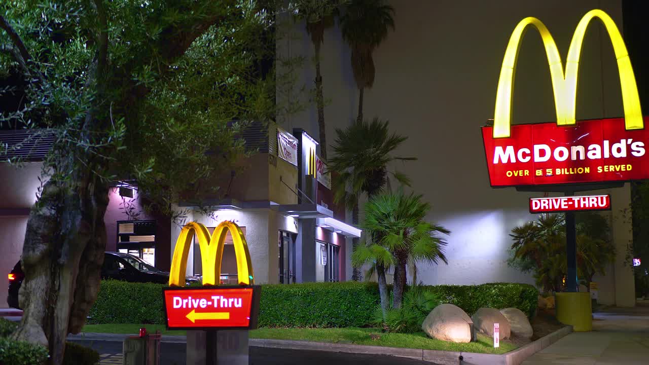 美国加利福尼亚州，洛杉矶——2021年7月14日:美国加利福尼亚州，洛杉矶，晚上，开车的麦当劳顾客使用“得来速”服务购买快餐视频素材