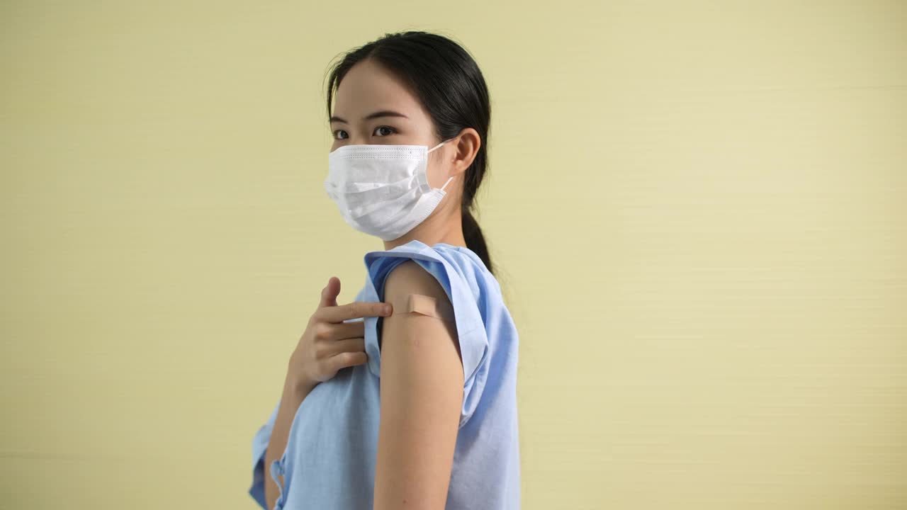 接种疫苗后，亚洲女孩在绷带上指指点点视频素材