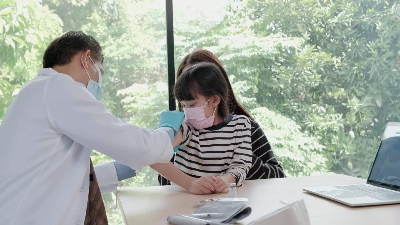 男医生在儿科诊所给亚洲女孩注射疫苗。视频素材