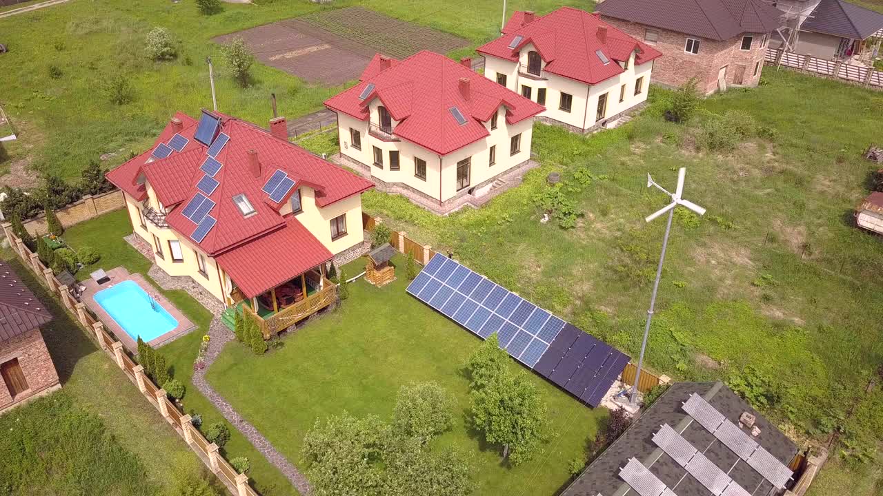 鸟瞰住宅私人住宅，屋顶上有太阳能电池板和风力发电机涡轮机。视频素材
