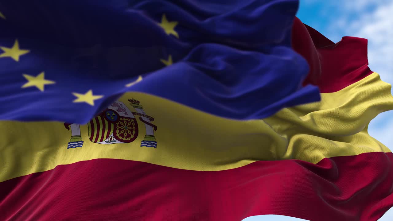 迎风飘扬的西班牙国旗和前景模糊的欧盟国旗视频素材