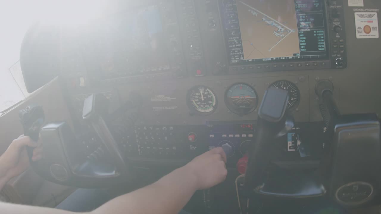 年轻的成年女飞行员设置起飞电源并与控制塔沟通视频素材