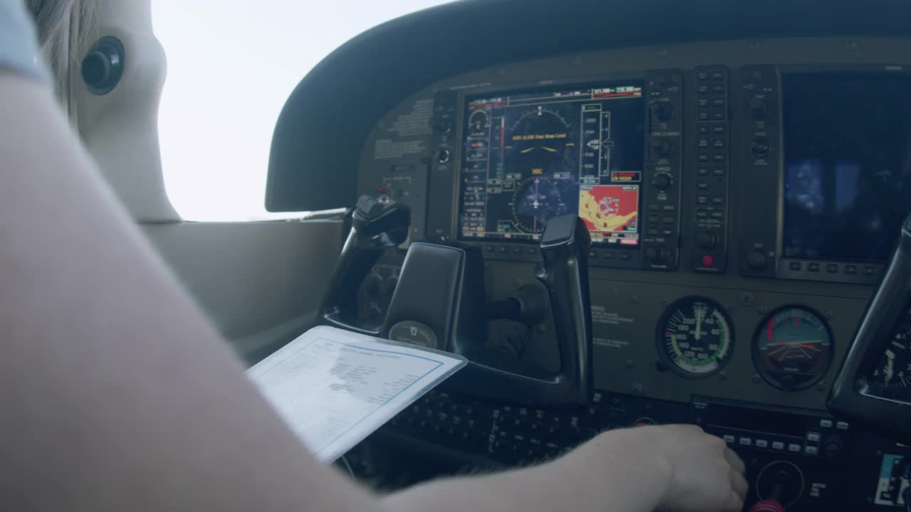 年轻的成年女飞行员在一架小型单引擎飞机上打开油门，打开燃油泵，将混合气控制设置为Full Rich以启动引擎视频素材