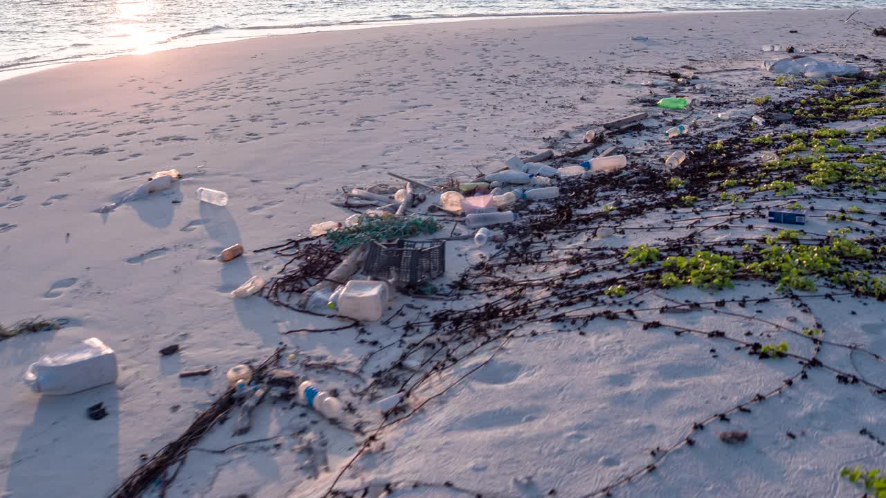用过的塑料瓶被冲上海滩的细节镜头视频下载