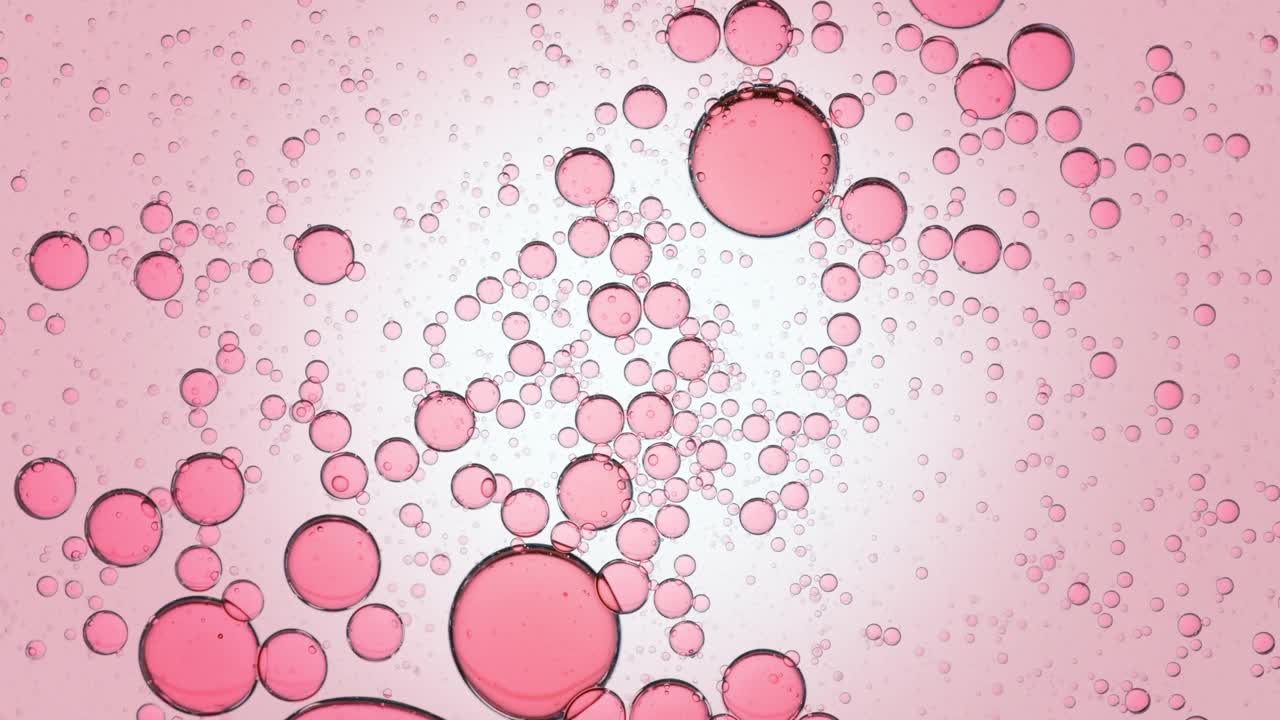 粉红色的透明气泡在透明液体中自发运动视频素材