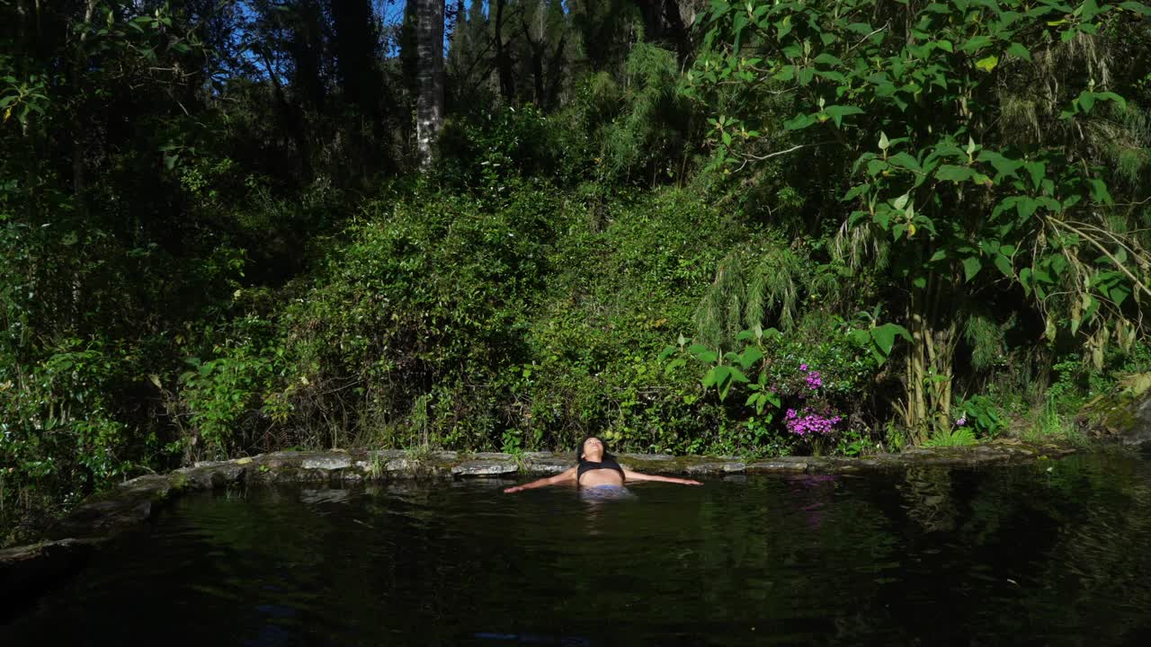 一个拉丁女子在一个天然湖泊里享受水视频下载