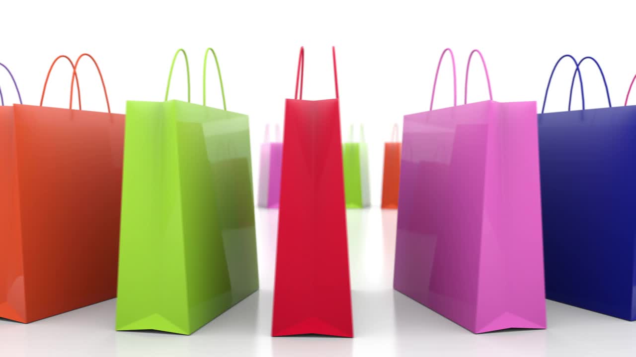 五颜六色的消费者购物袋旋转隔离在白色的背景视频素材