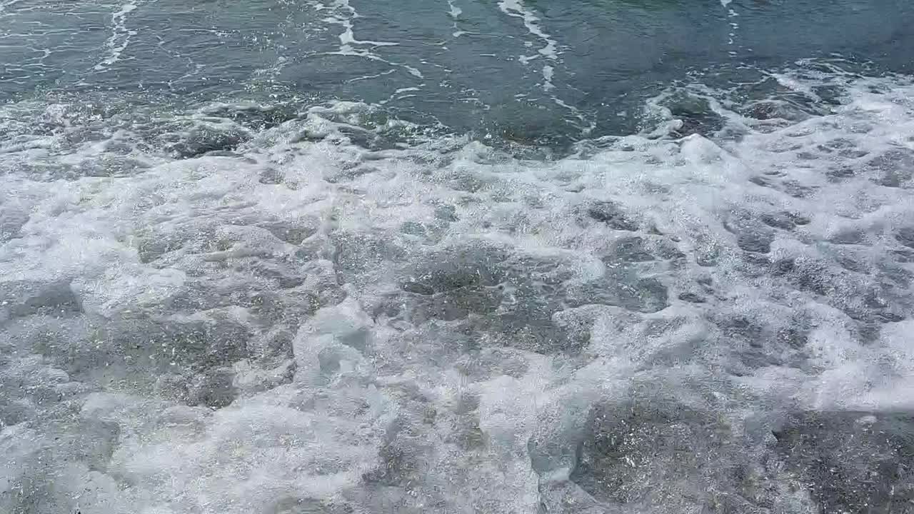 在地中海的西班牙马拉加海滩上海浪的运动和海水的退潮视频下载
