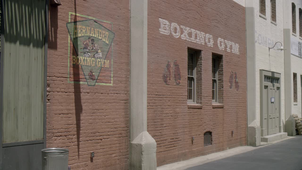 后巷入口宽角拳击馆。砖建筑上的标志写着“赫尔南德斯拳击馆”。建筑物上可见窗户。实际上是索尼工作室。视频下载