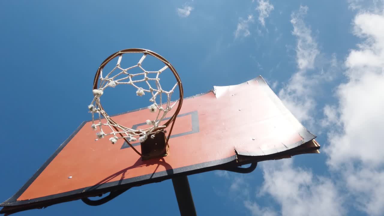 在公共体育场的天空背景上的旧篮球框。视频素材