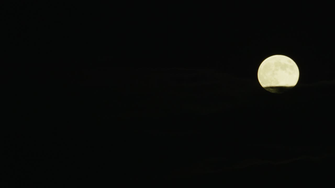 中等角度的月亮在天空中升起。视频素材