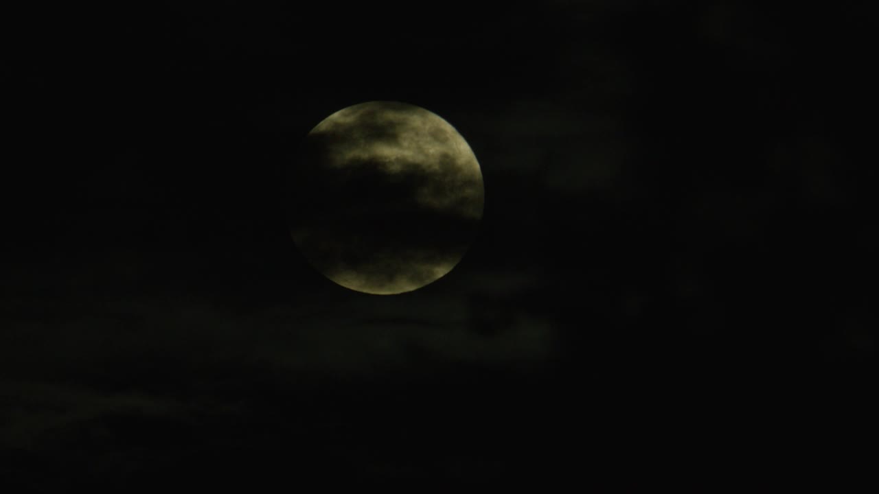 满月从云间的天空升起的闭合角度。视频下载