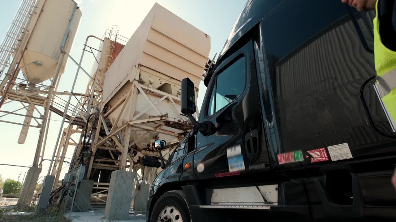 卡车司机钻进他的卡车去运输货物视频素材