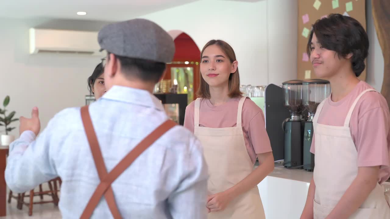 4K亚洲男人咖啡馆老板在开业前给兼职员工做简报视频素材