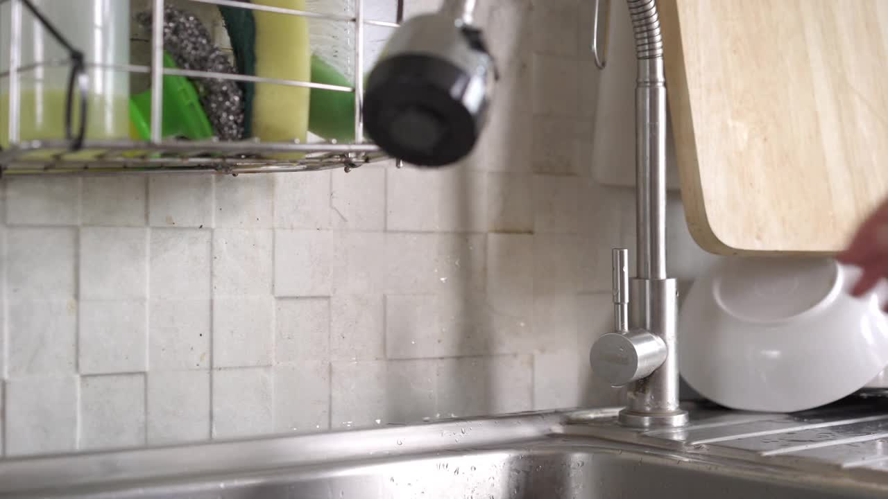 女人用手打开和关闭厨房水槽上的水龙头视频下载