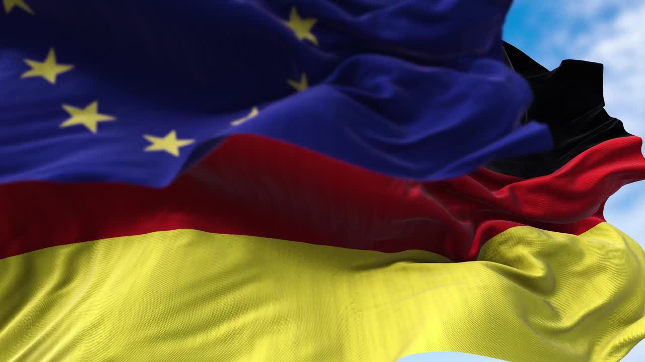 迎风飘扬的德国国旗和前景模糊的欧盟国旗视频素材