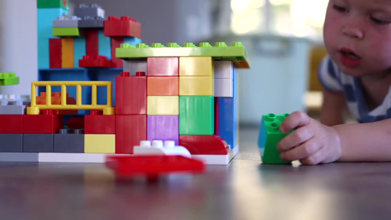 一个小男孩的特写肖像正在玩积木玩具视频素材