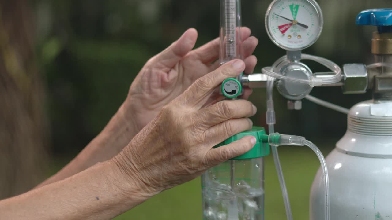 老年妇女手持流量调节器和氧气瓶视频素材