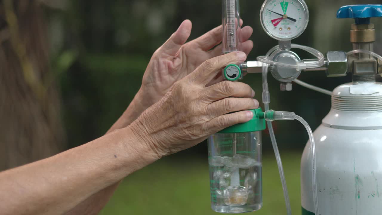 老年妇女手持流量调节器和氧气瓶视频素材