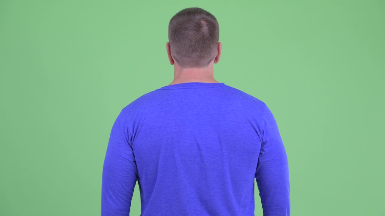 摄影棚拍摄的男子背面的绿色背景视频下载