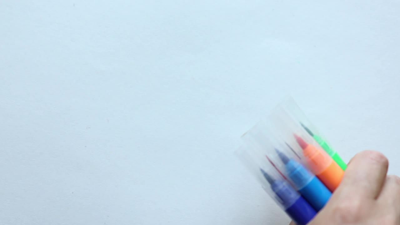 用手在白色的背景上放置一些彩色的移动标记。回到学校绘画用品的概念视频素材