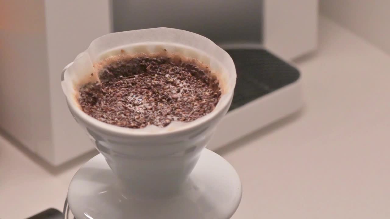 咖啡流程:将热水倒在磨碎的咖啡粉上，使用咖啡过滤滴漏器，供咖啡师早上冲泡视频下载