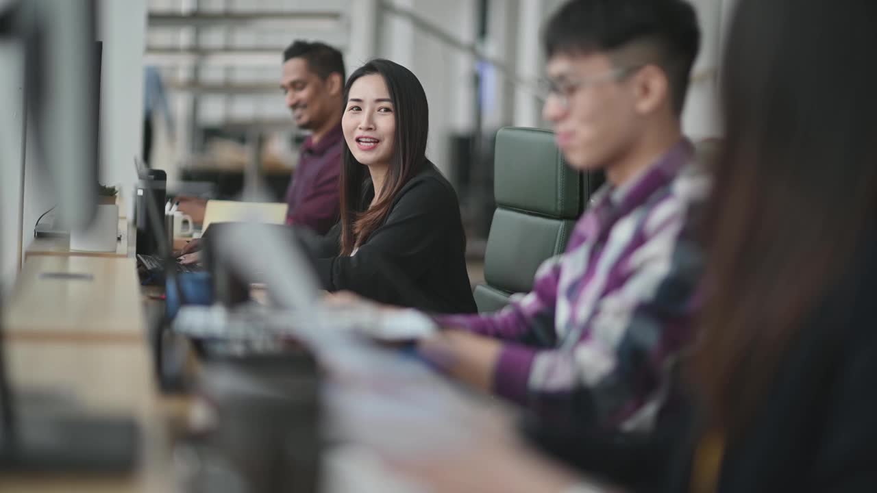 美丽的亚洲中国女人微笑着和她的同事在她的工作场所视频下载