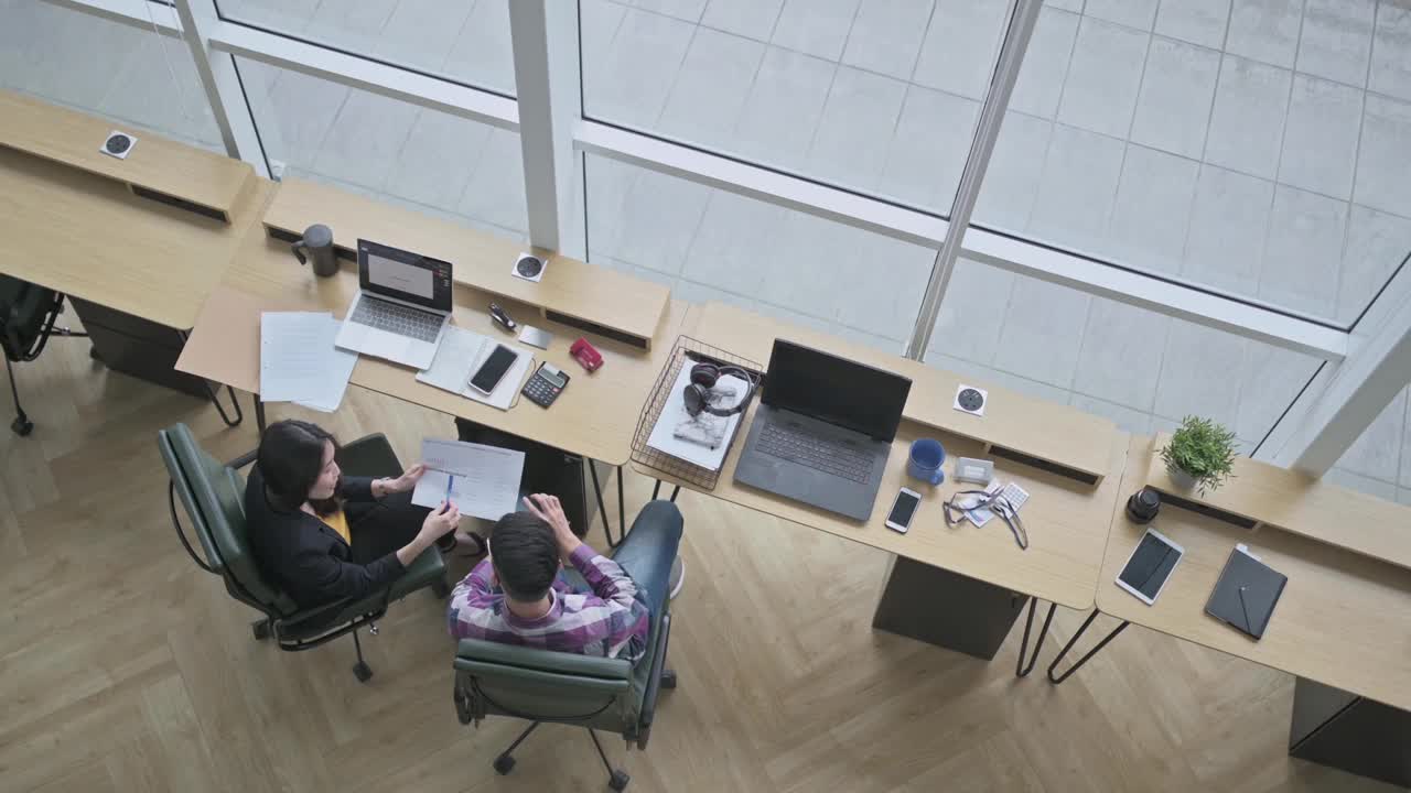 俯视图亚洲华裔女同事向她的学员解释在办公室工作场所的讨论视频素材