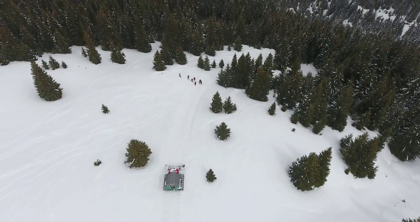 雪地车在雪坡上行驶鸟瞰图，雪道外坡救生紧急救援，山上滑雪事故视频下载