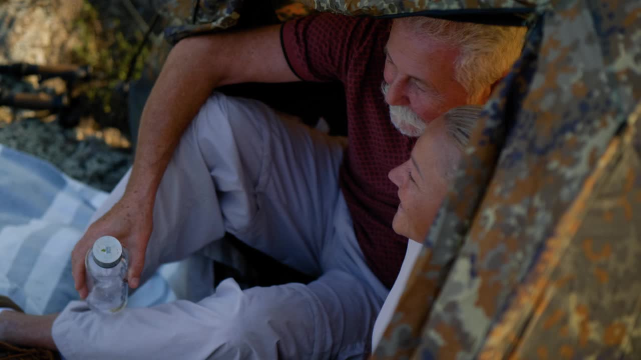 一对快乐的退休老夫妇在山上露营，在山顶的帐篷里休息视频下载