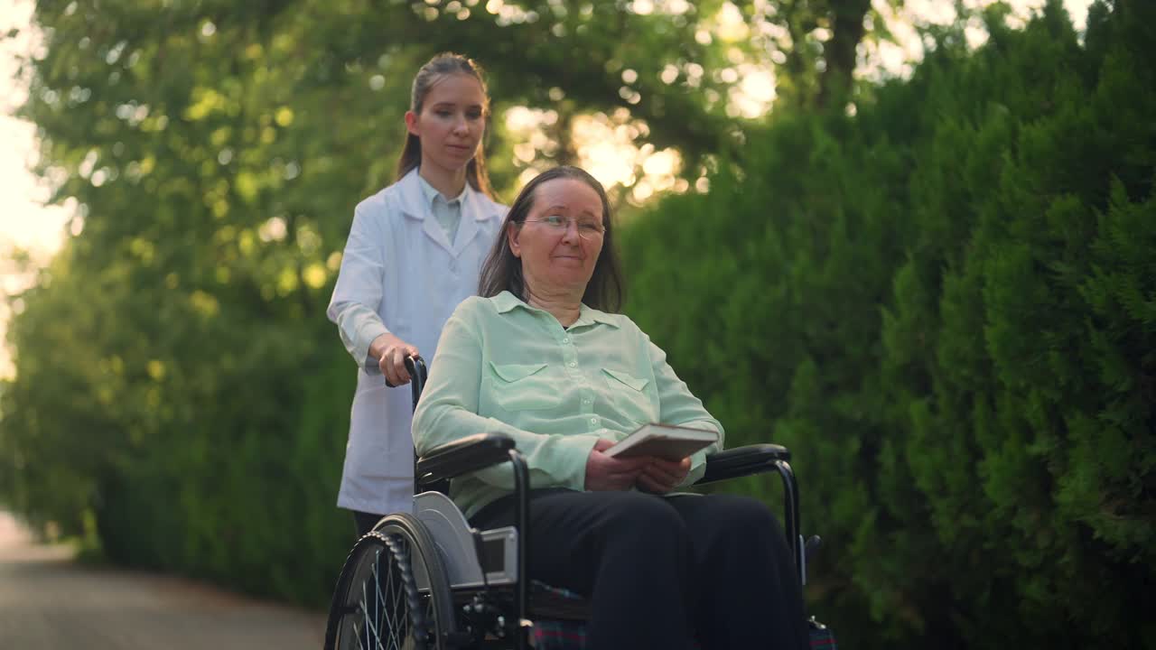专业女性医护人员照顾轮椅上的老年妇女视频素材