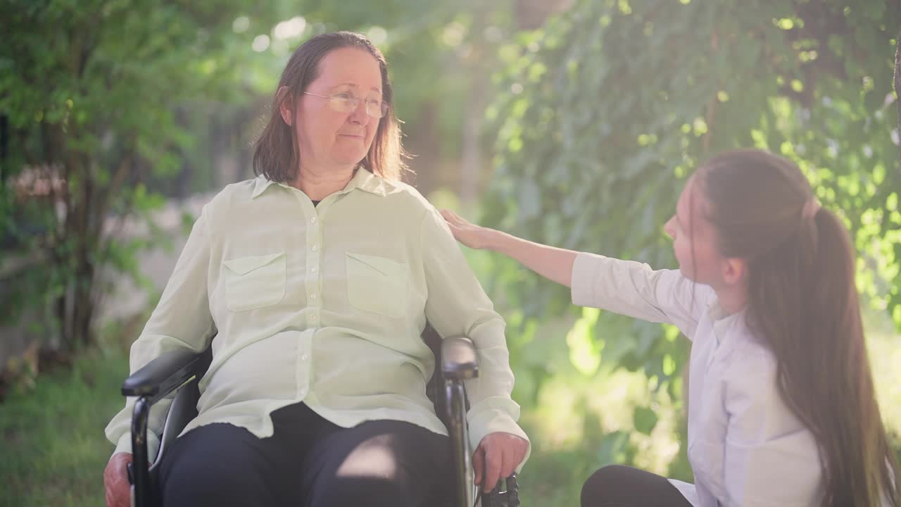 专业女性医护人员照顾轮椅上的老年妇女视频素材